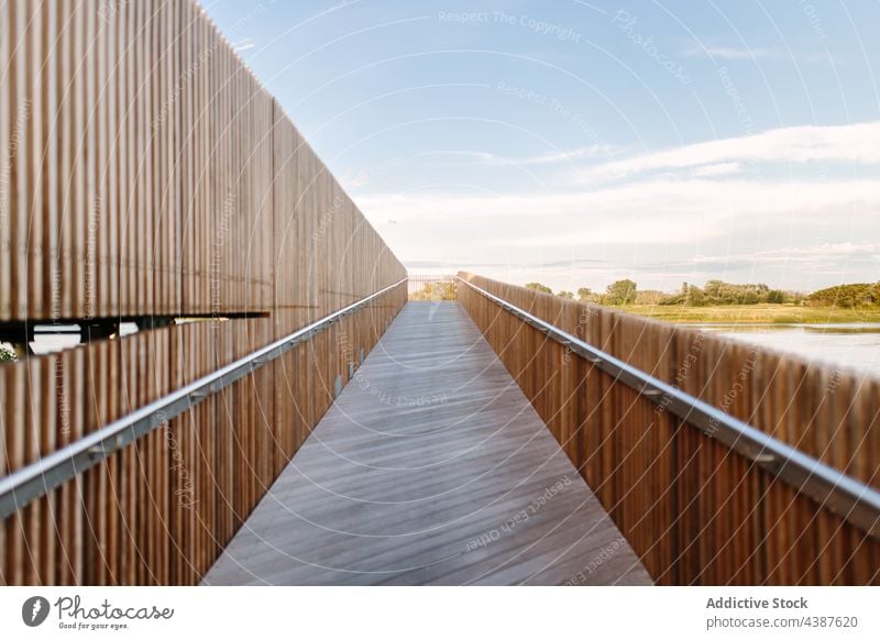 Hölzerne Promenade im Dorf im Sommer hölzern Landschaft Stauanlage modern Zeitgenosse Laufsteg Fußweg Blauer Himmel Saison sonnig Sonnenlicht Holz Nutzholz