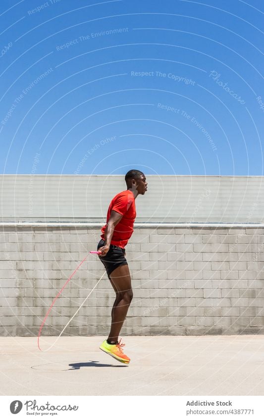 Fit schwarzer Sportler springt Seil während des Trainings Hüpfseil springen Moment Herz Übung aktiv Energie Athlet männlich ethnisch Afroamerikaner Mann Fitness