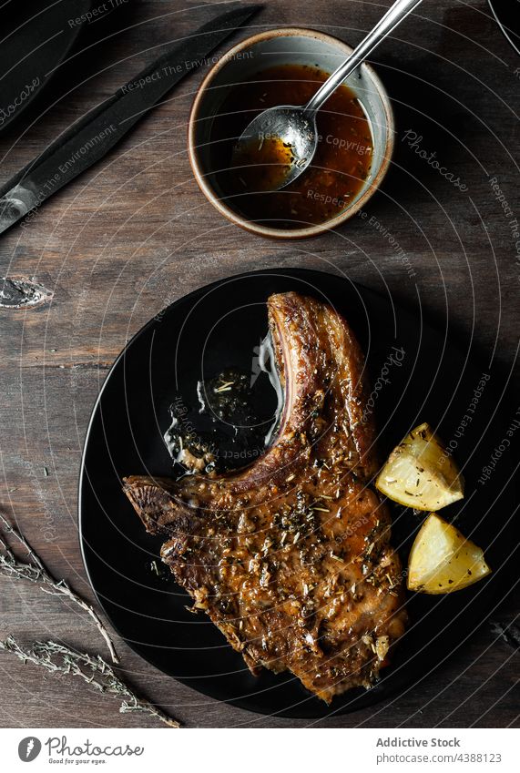 Nahaufnahme eines Tellers mit Schweinefilet mit Kartoffeln und Honig auf einem Tisch von oben gesehen Lebensmittel Fleisch Schweinefleisch Knochen Mahlzeit