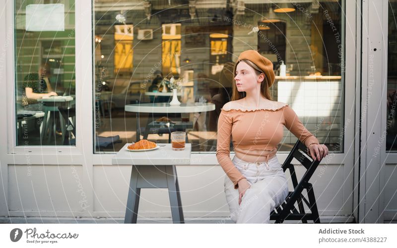 Stilvolle Frau sitzt am Tisch in einem Straßencafé Frühstück Café Kaffee Croissant Terrasse lecker Dessert Französisch Lebensmittel geschmackvoll Getränk Morgen