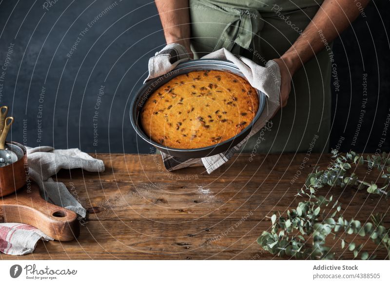 Crop Mann hält Teller mit Kürbiskuchen Pasteten rustikal Dessert lecker Holz männlich Küchenchef Koch Tisch heimwärts Gebäck Speise Mahlzeit süß Snack frisch