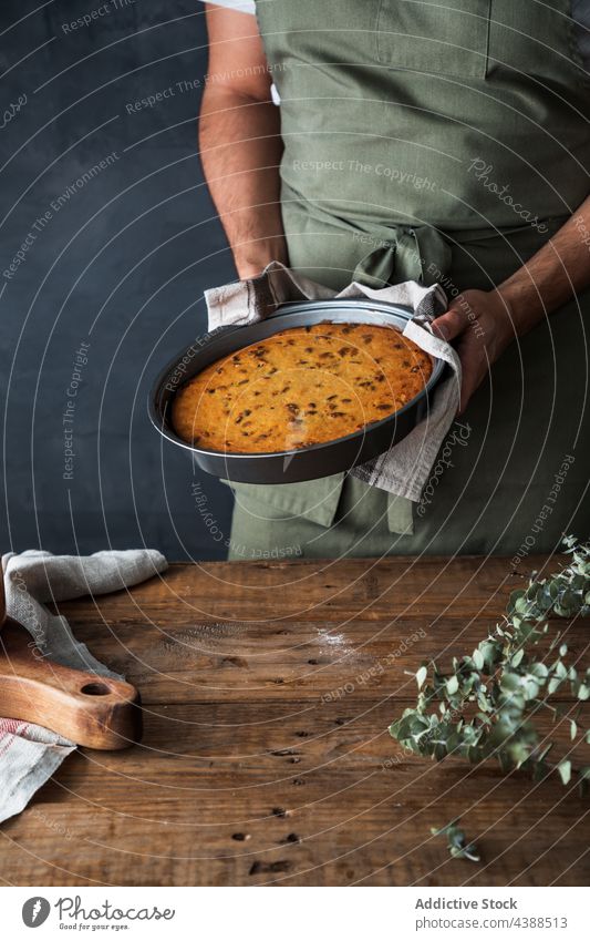 Crop Mann hält Teller mit Kürbiskuchen Pasteten rustikal Dessert lecker Holz männlich Küchenchef Koch Tisch heimwärts Gebäck Speise Mahlzeit süß Snack frisch