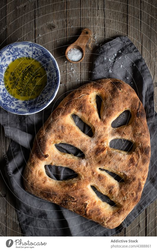 Gebackenes Fougasse-Brot auf dem Tisch mit Salz und Öl fougasse gebacken Brotlaib Tradition Bäckerei köstlich selbstgemacht lecker frisch geschmackvoll Löffel