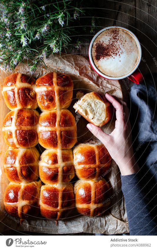 Hand mit Hot Cross Buns Brötchen Kaffee Glasur frisch heiß Lebensmittel heiße Querbrötchen Hauch Weizen gebacken weich Korn Mehl Bäckerei Müsli organisch