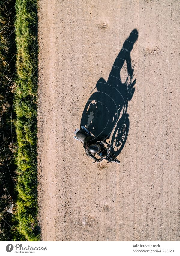 Unbekannter Motorradfahrer fährt auf einer Landstraße Mitfahrgelegenheit Fahrrad Straße Landschaft Person Laufwerk ländlich Fahrzeug Verkehr reisen Abenteuer