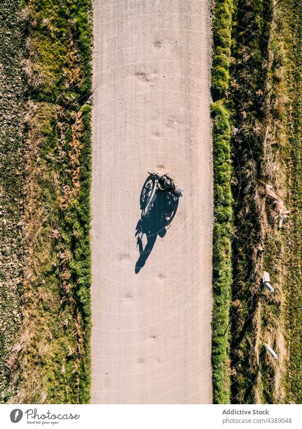 Unbekannter Motorradfahrer fährt auf einer Landstraße Mitfahrgelegenheit Fahrrad Straße Landschaft Person Laufwerk ländlich Fahrzeug Verkehr reisen Abenteuer