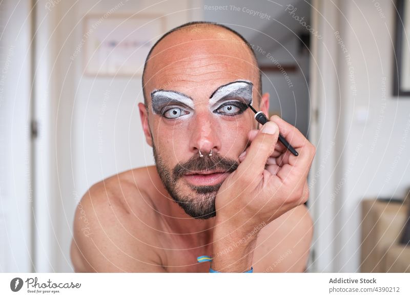 Bärtiger Mann trägt Make-up auf die Augen auf bewerben Drag Queen Transgender Kajal Augenbraue Kosmetik Geschlecht Gesicht Linse männlich Piercing Vollbart