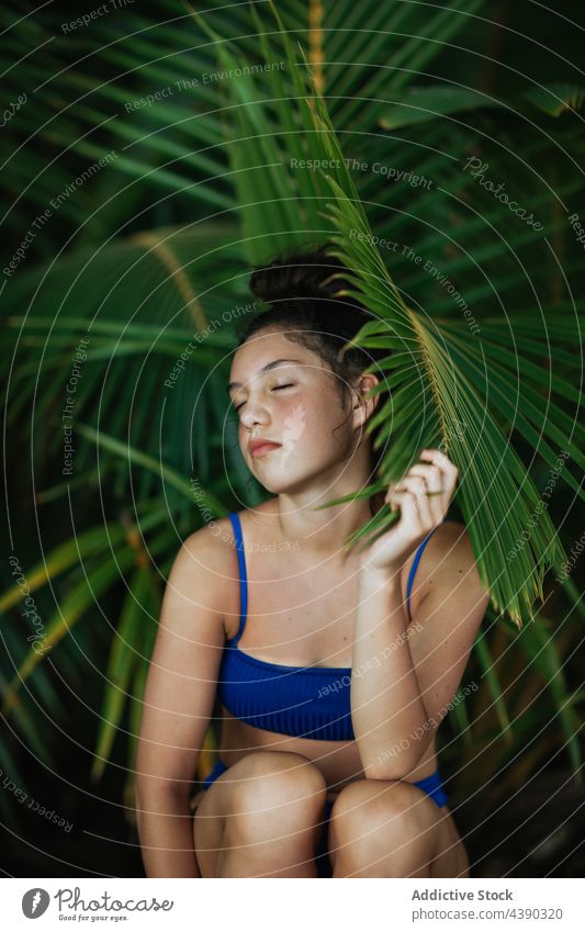 Sinnliche Frau im Bikini unter Palmenblättern Handfläche tropisch Sommer Blatt Strand Natur reisen sinnlich Urlaub Feiertag genießen jung exotisch Laubwerk