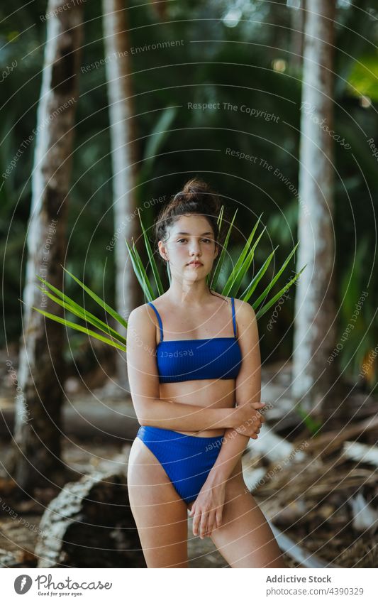 Friedliche Frau im Park stehend mit Palmenblatt Handfläche Garten tropisch Baum Blatt Ast exotisch Natur Sommer guanacaste uvita Costa Rica Gelassenheit