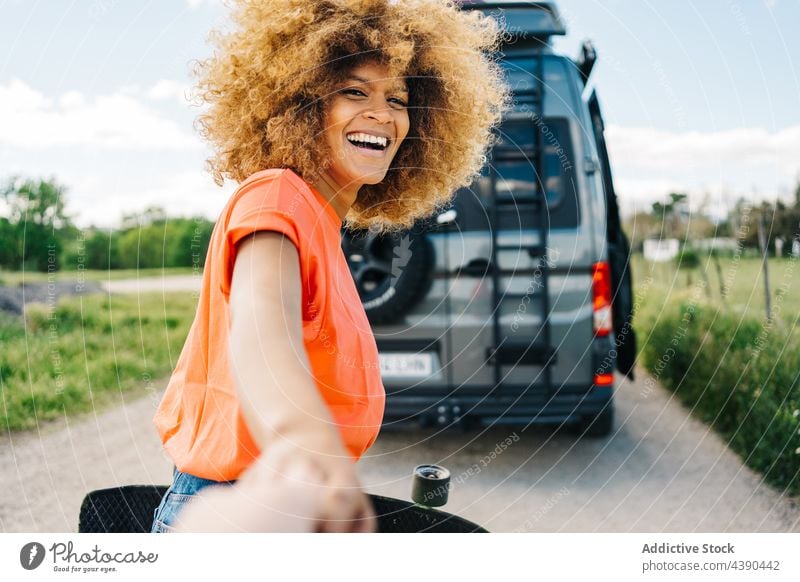 Schwarze Reisende führt Freund zum Wohnmobil Frau Reisender Autoreise mir folgen Lächeln Sommer Landschaft Zusammensein Blei Longboard Kleintransporter Glück