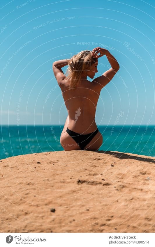 Anonyme Frau beim Sonnenbaden am felsigen Strand MEER Sommer Stein allein verträumt Urlaub oben ohne sich[Akk] entspannen blond Erholung reisen Freiheit