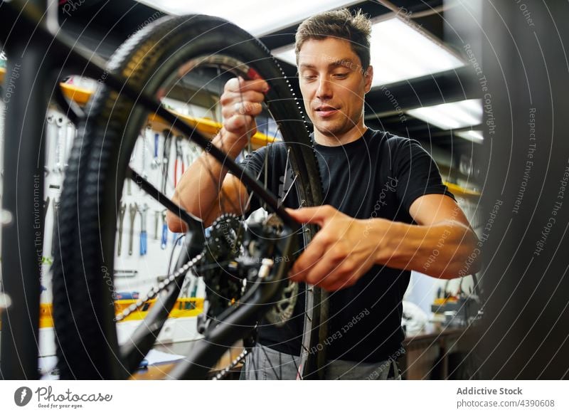 Mann repariert Fahrradrad in der Garage Techniker Reparatur befestigen Rad professionell Arbeit Dienst männlich Erwachsener Fahrradfahren Mechaniker Werkstatt