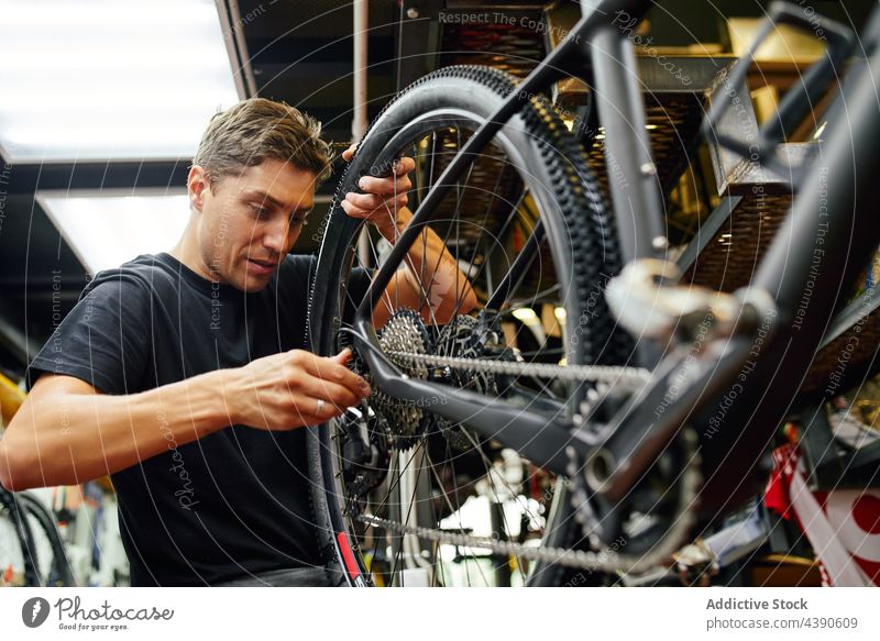 Mann repariert Fahrradrad in der Garage Techniker Reparatur befestigen Rad professionell Arbeit Dienst männlich Erwachsener Fahrradfahren Mechaniker Werkstatt