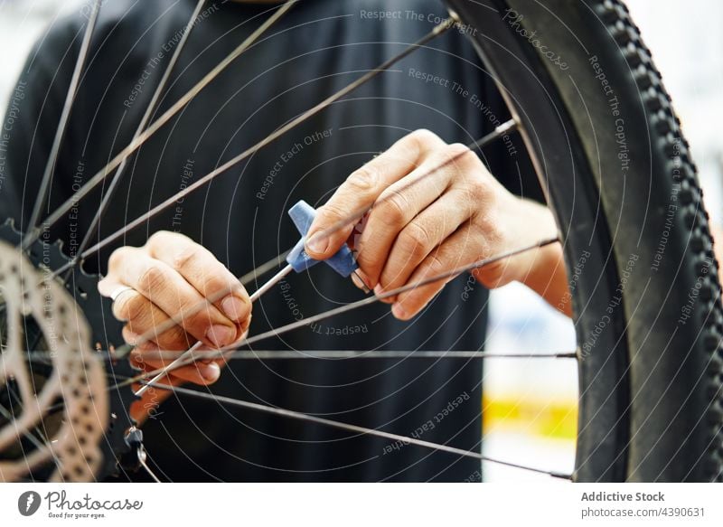 Fahrradmechaniker schraubt Rad ein Mann fixieren schrauben Arbeit Garage manuell Mechaniker Dienst männlich Schraubendreher Reparatur Werkstatt Fahrzeug Verkehr