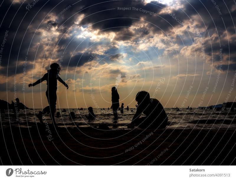 Silhouetten von Menschen spielen im Meer an einem öffentlichen Strand Landschaft Himmel Sand Abend Urlaub MEER Sonne Sonnenuntergang Sommer jung Wasser Natur