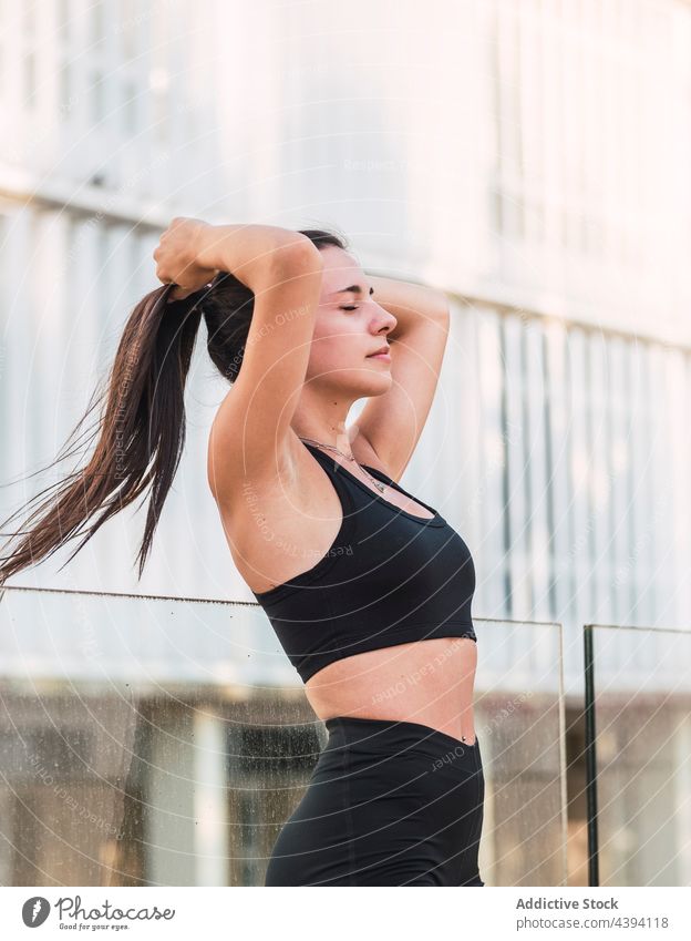 Joggerin mit Pferdeschwanz beim Training Sportlerin Frisur Fitness vorbereiten Straße urban passen Wellness Frau jung Augen geschlossen Athlet Wohlbefinden üben