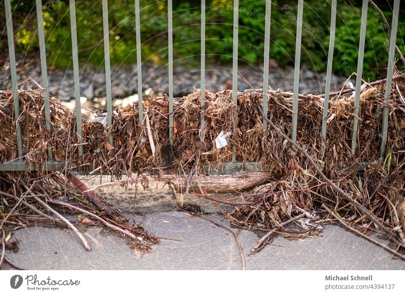 Treibgut der Überschwemmung an einem Gitter (Flutkatastrophe, Juli 2021, Volmetal, Hagen, NRW) kaputt zerstört Zerstörung Vergänglichkeit Klimawandel unheilvoll