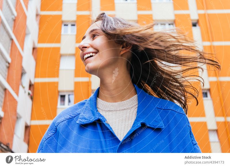 Glückliche Frau steht in der Stadt und lacht Lachen hell Farbe Spaß haben Großstadt urban heiter Straße lebhaft Freude sorgenfrei Stil froh Optimist aufgeregt