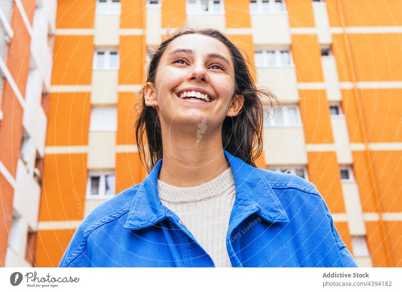 Glückliche Frau steht in der Stadt und lacht Lachen hell Farbe Spaß haben Großstadt urban heiter Straße lebhaft Freude sorgenfrei Stil froh Optimist aufgeregt