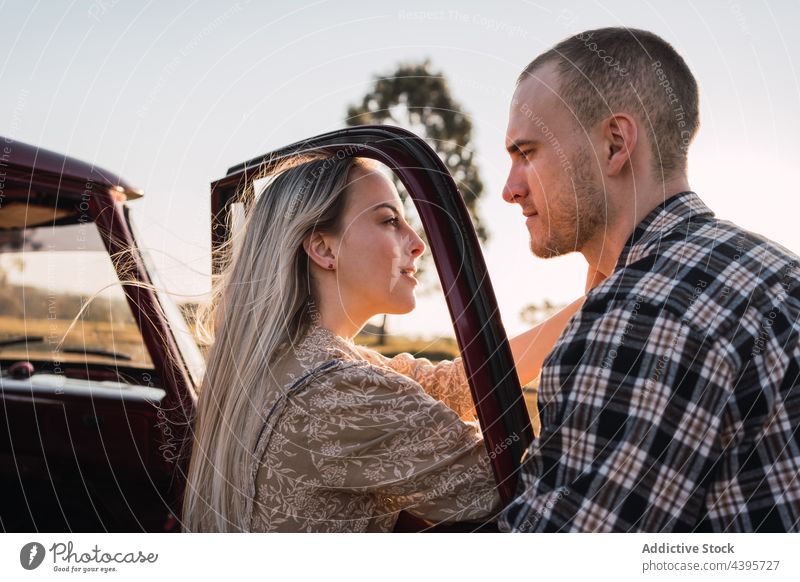 Zärtliches Paar in der Nähe eines Oldtimers auf dem Lande PKW altehrwürdig retro Liebe romantisch Abend Gesicht berühren Angebot altmodisch Landschaft Sommer