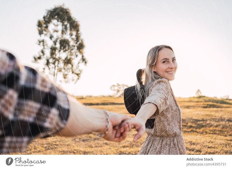 Paar hält sich abends auf einem Feld an den Händen mir folgen Händchenhalten Sommer Zusammensein Abend Sonnenuntergang romantisch Liebe Glück Partnerschaft