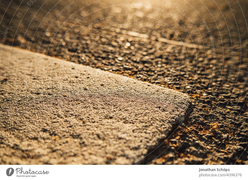 weißer Markierungstreifen auf der Straße Makro Straßenverkehr Nahaufnahme Warmes Licht minimalistisch geometrisch Asphalt draußen Straßenbelag Stadt urban hart