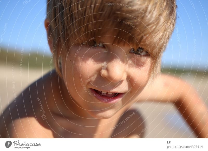 Gesicht eines schönen Kindes, das am Meer in die Kamera lächelt positive Emotion Lächeln Strand einzeln vereinzelt Single abstrakt Bewegung fließen Kinderspiel