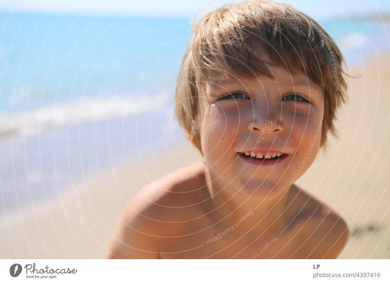 Gesicht eines schönen Kindes, das am Meer in die Kamera lächelt positive Emotion Lächeln Strand einzeln vereinzelt Single abstrakt Bewegung fließen Kinderspiel