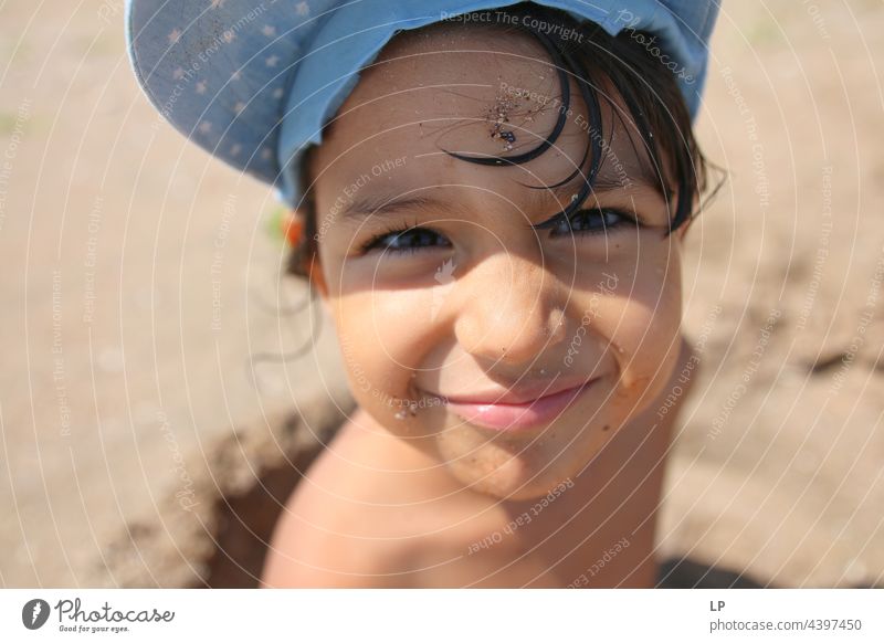 Gesicht eines schönen Kindes, das am Meer in die Kamera lächelt positive Emotion Lächeln Strand einzeln vereinzelt Single abstrakt Bewegung fließen Kinderspiel