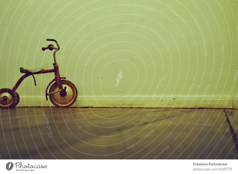 geparkte Kindheit. Spielplatz Mauer Wand Fassade Verkehr Verkehrsmittel fahren stehen Spielen treten Kleinmotorrad Dreirad toben parken Parkett warten Fahrzeug