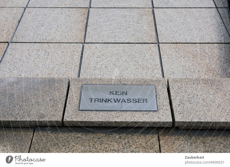 Kein Trinkwasser Schild auf Steinplatten eines trockenen Brunnens als Symbol für Wassermangel Mangel Dürre ausgetrocknet Wasserspiel Platten kein trinkwasser