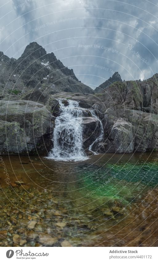 Schneller Wasserfall auf einem Bergrücken unter bewölktem Himmel Kamm Teich wolkig Natur Hochland Landschaft Bewegung Sonnenuntergang Energie Berge u. Gebirge