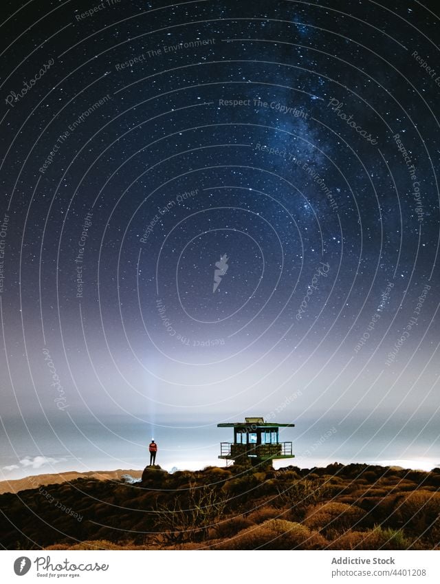 Person am Strand unter Sternenhimmel mit Milchstraße bei Nacht sternenklar Himmel Milchstrasse glühen retten Turm Natur dunkel Weltall leuchtend schimmern