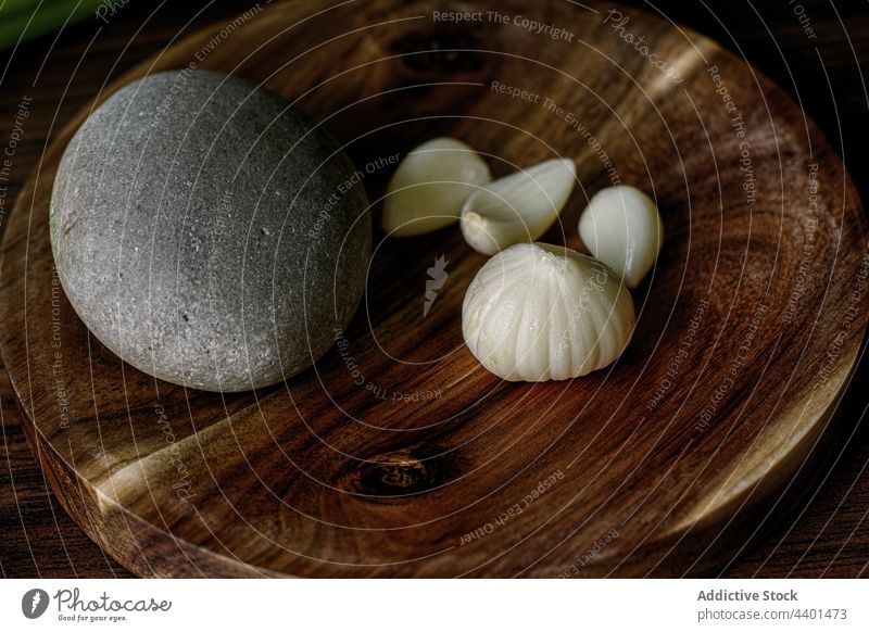 Frischer Knoblauch im Mörser auf dem Tisch Grinden Minenwerfer Kopf Gewürznelke frisch reif Bestandteil hölzern Stein Kieselsteine kulinarisch Ernährung