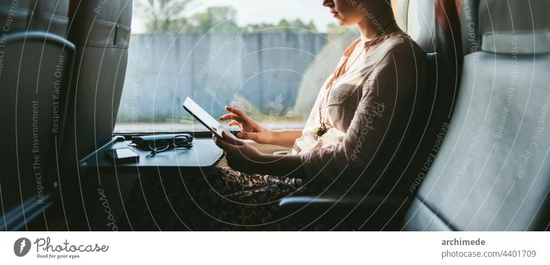 Frau, die mit dem Zug reist und ein Mobiltelefon benutzt reisen reisend Fenster Telefon Handy Arbeit beschäftigt Sitz Pendeln Pendler Transport Verkehr