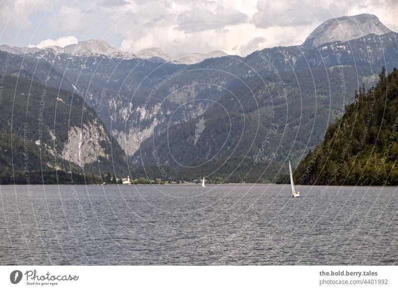 Segelboote am See mit Bergen im Hintergrund, bewölkter Himmel Sommer Landschaft Boot Wald Berge u. Gebirge Farbfoto Außenaufnahme Wasser Natur Wolken blau