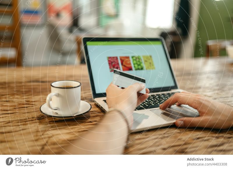 Crop-Mann beim Bezahlen mit Plastikkarte beim Online-Shopping Zahlung online Werkstatt Laptop Kauf bezahlen Orden Käufer e-Commerce Kunde verbrauchen Laden