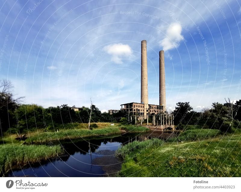 Lost Place - ein altes Kraftwerk an der Oder, das zwar gebaut, aber nie in Betrieb genommen wurde. 2 Schornsteine ragen in den blauen, leicht bewölkten Himmel.