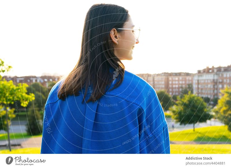 Frau in stilvollem Outfit auf einem Hügel in der Stadt trendy Stil Großstadt sonnig urban jung grün Wiese Rasen Sonnenlicht Sonnenschein sorgenfrei genießen