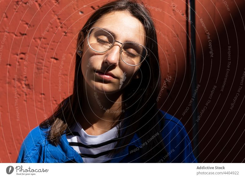 Verträumte Frau genießt das sonnige Wetter in der Stadt verträumt Sonnenlicht genießen sorgenfrei Augen geschlossen Straße ruhig Schatten Inhalt urban Großstadt