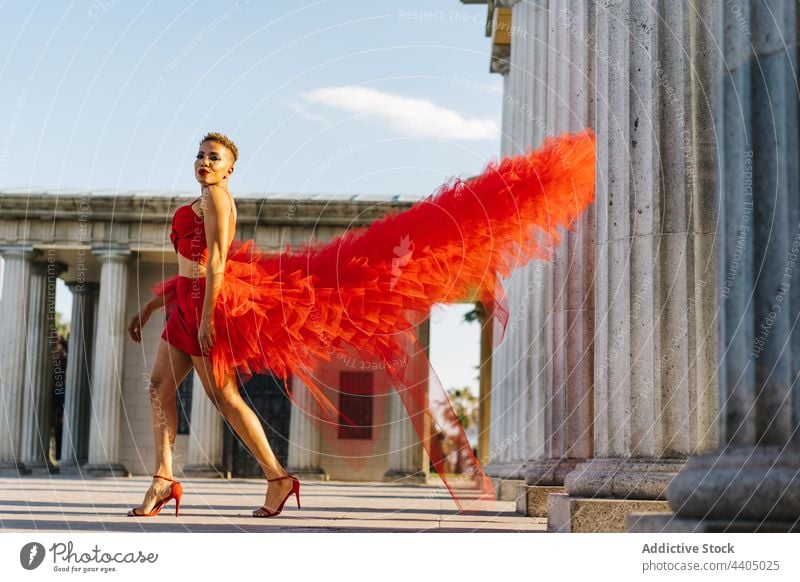 Modische schwarze Frau im fliegenden Kleid auf der Straße fliegendes Kleid Mode Stil Individualität cool selbstbewusst Spaziergang Porträt Kolonnade alt modern