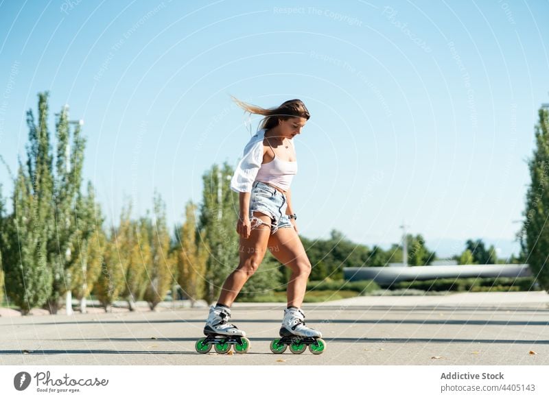 Frau in Rollschuhen und mit Stunt Rollerblade Trick Ausgeglichenheit Skater Sommer Rad Straße Aktivität üben sonnig Sonnenlicht Sommerzeit passen urban