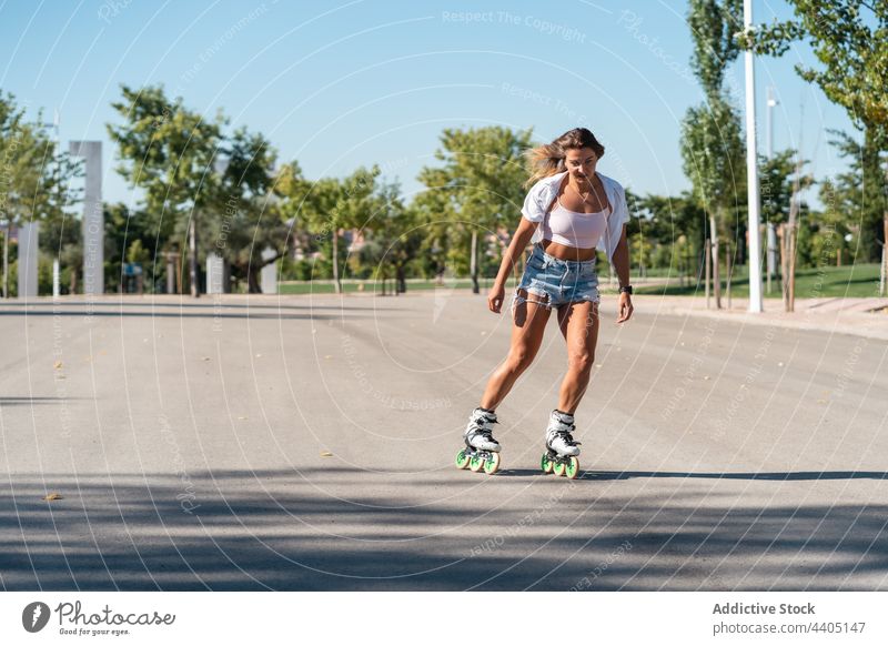 Frau in Rollschuhen und mit Stunt Rollerblade Trick Ausgeglichenheit Skater Sommer Rad Straße Aktivität üben sonnig Sonnenlicht Sommerzeit passen urban