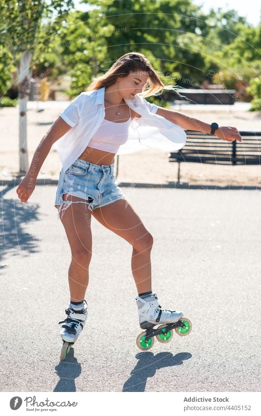 Frau in Rollschuhen und mit Stunt Rollerblade Trick Ausgeglichenheit Skater Sommer Rad Straße Aktivität üben sonnig Sonnenlicht Sommerzeit passen urban