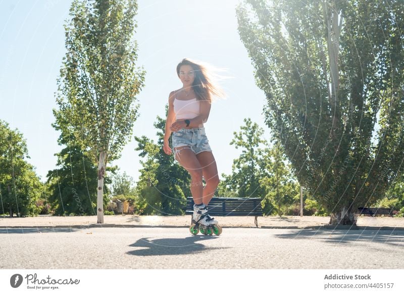 Frau in Rollschuhen und mit Stunt Rollerblade Trick Ausgeglichenheit Skater Sommer Rad Straße Aktivität üben sonnig Sonnenlicht Sommerzeit passen urban