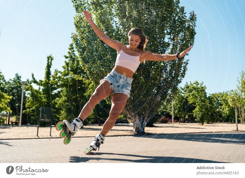 Frau in Rollschuhen und mit Stunt Rollerblade Trick Ausgeglichenheit Skater Sommer Rad Straße Aktivität üben sonnig Sonnenlicht Sommerzeit passen urban