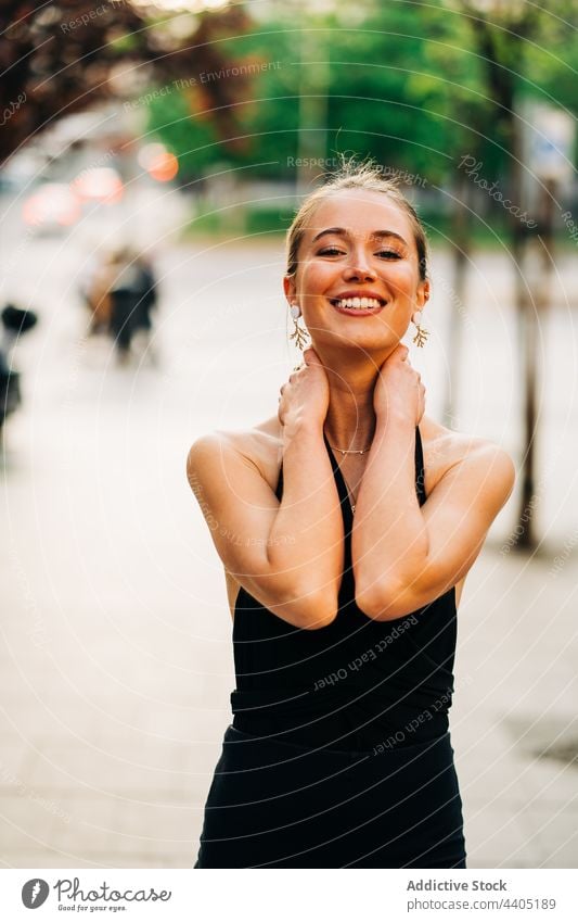 Fröhliche, trendige Frau, die lächelnd auf der Straße steht Stil Großstadt trendy Lächeln Tasthals heiter Outfit urban positiv charmant Vorschein Individualität