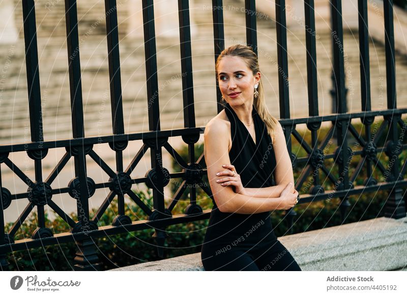 Lächelnde elegante Frau in der Stadt Straße Anmut Großstadt Outfit Stil trendy Inhalt verschränkte Arme urban Glück sitzen Bank charmant Mode Freude froh