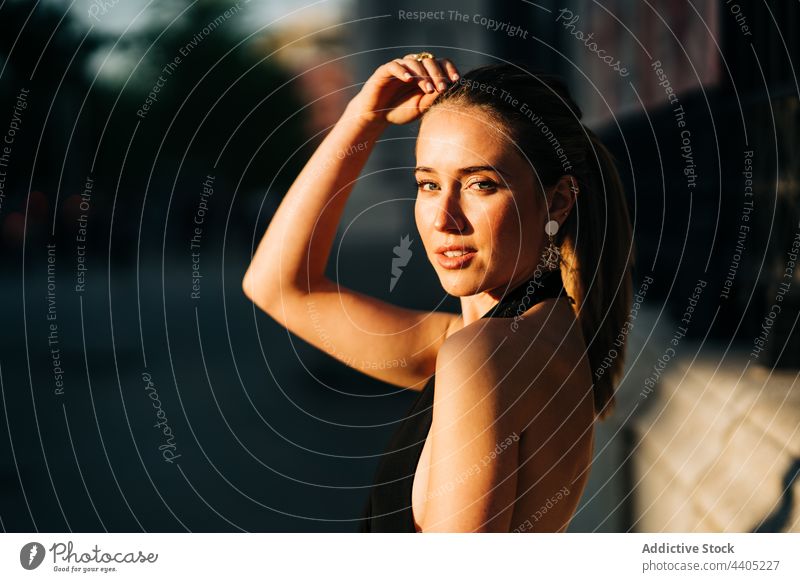 Erfreute stilvolle Frau steht auf der Straße Stil Großstadt trendy Lächeln heiter Sonnenlicht Glück Mode Optimist Freude charmant Sommer Inhalt modern Gebäude