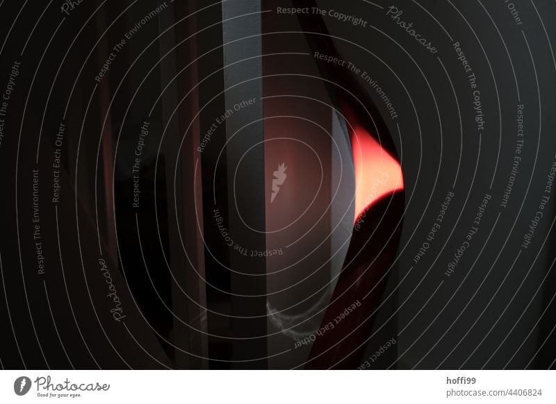 ein Sonnenstrahl beleuchtet partiell einen roten Handlauf eines Treppengeländer in einem sonst dunklen Raum hell dunkel minimalistisch weiß schwarz Gegensätze
